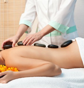 Female massage therapist performing holistic massage techniques on her client.