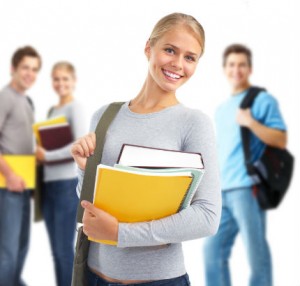 Female exercise science student in the foreground holding her books.